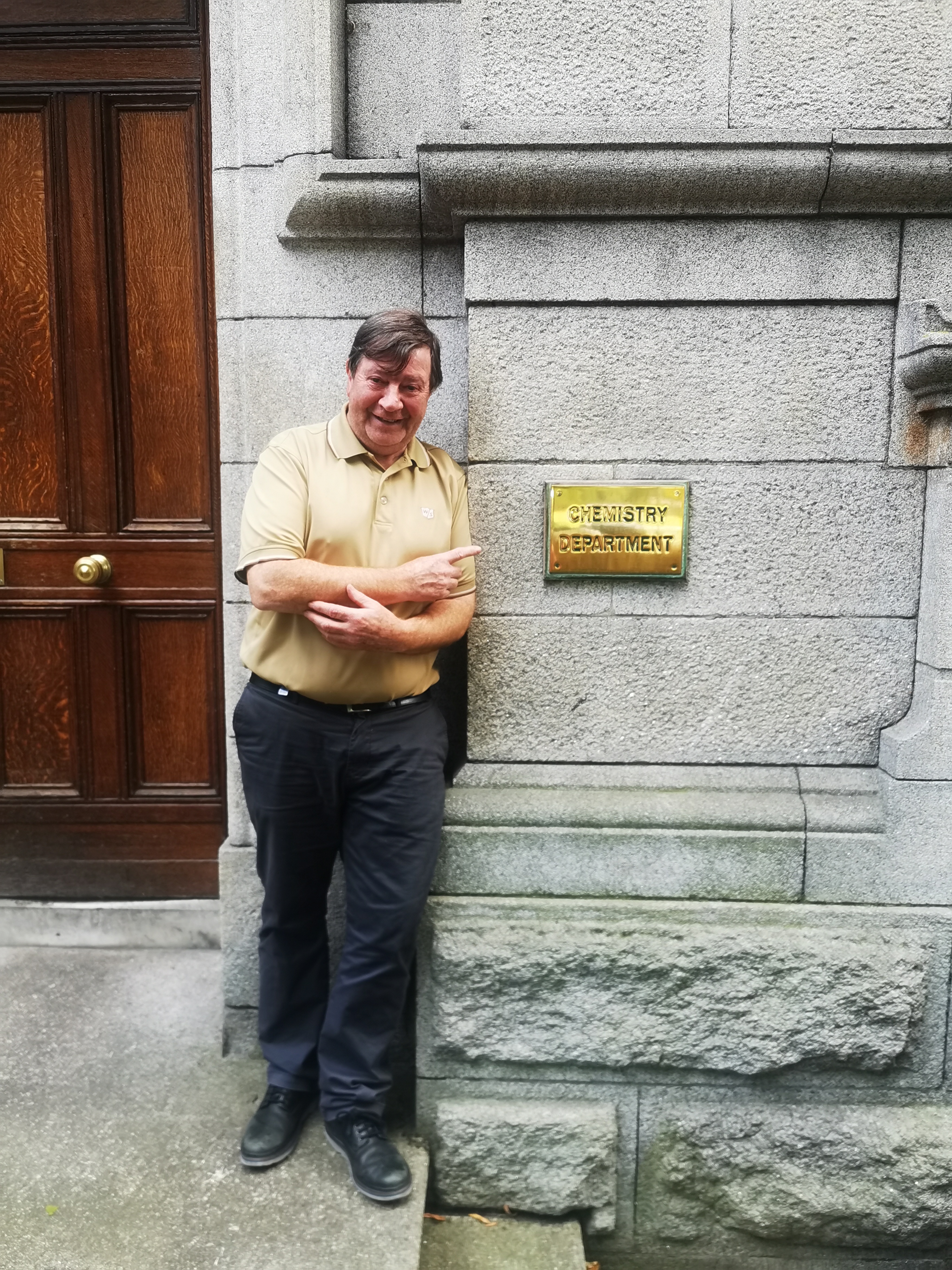 Patsy stands beside the School of Chemistry Plaque