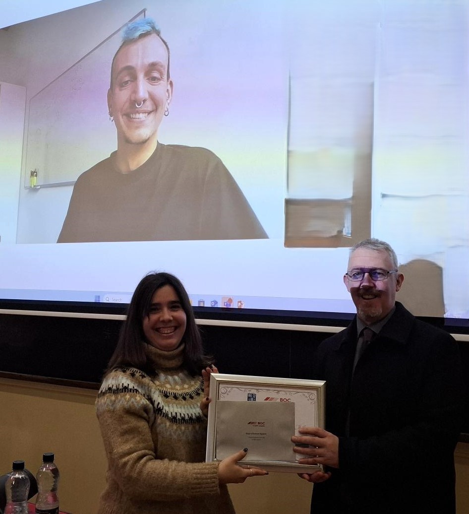 Natalia Garcia Domenech accepts an award from James Kelch from BOC Gases on behalf of Inigo Iribarren Aguierre seen on the screen in the background